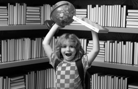 Téléchargez les photos : Écolier avec globe mondial et échecs, enfance. Etudiant en classe à l'école primaire. Enfant étudiant en classe à l'école primaire - en image libre de droit