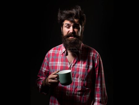 Téléchargez les photos : Homme barbu bâillant tenir tasse de thé. Réveille-toi. Thé du matin. Un homme avec une tasse. Homme bâillant avec une tasse de café. Un barbu bâillant, une tasse de thé. Bonjour. Bonjour. Après le thé. Face bâillante - en image libre de droit