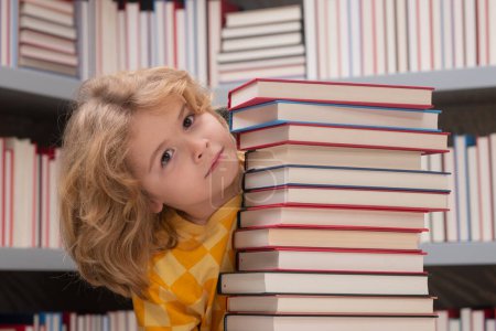 Photo for Intellectual child, clever pupil. School child studying in school library. Kid reading book in library on bookshelf background - Royalty Free Image