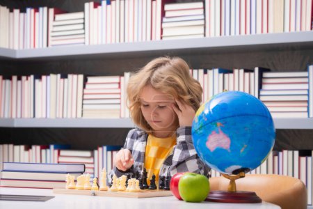 Photo for Child play chess. Clever concentrated and thinking child playing chess. Child boy developing chess strategy, playing board game - Royalty Free Image