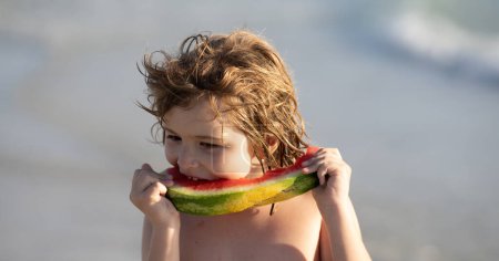 Photo for Vacation and traveling with kids. Summer watermelon fruit for children. Child play by the sea and eat watermelon. Little boy biting watermelon on beach. Kid is picking watermelon outdoor - Royalty Free Image