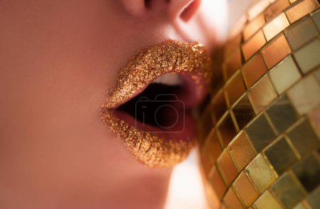 Foto de Los labios dorados. Moda seductora. Hermoso maquillaje. Labio de metal dorado - Imagen libre de derechos