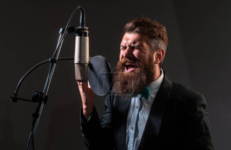 Téléchargez les photos : Chanteur chantant avec un microphone dans un studio d'enregistrement - en image libre de droit