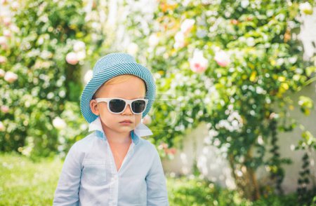 Téléchargez les photos : Adorable garçon cool enfant dans des lunettes de soleil à l'extérieur. Mode pour enfants. Patron enfants - en image libre de droit