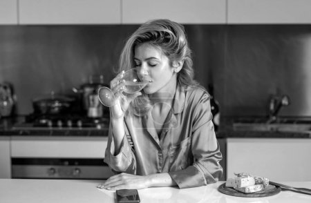 Photo for Woman drink wine in a kitchen. Alcohol abuse - Royalty Free Image