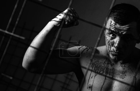Photo for Murderer brutal aggressive guy. Halloween concept. Aggressive person. Injured soldier. Pain and injury. Aggressive monster. Body soiled blood. Prison for monster. Psycho mad man. Psychic disease. - Royalty Free Image