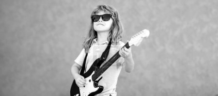 Photo for Kid with guitar. Portrait of cute child boy at guitar practice, funny rock child with guitar. Children music. Rock music, pop music. Kids music concept banner - Royalty Free Image
