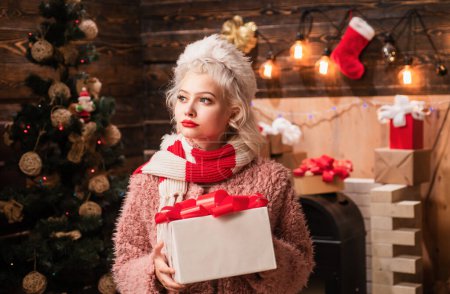 Photo for Christmas interior. Friendly and joy. Event. Crazy comical face. Give a wink. Sensual girl for Christmas. Christmas time. Having fun. True Emotions. Winter woman wearing red santa claus hat - Royalty Free Image