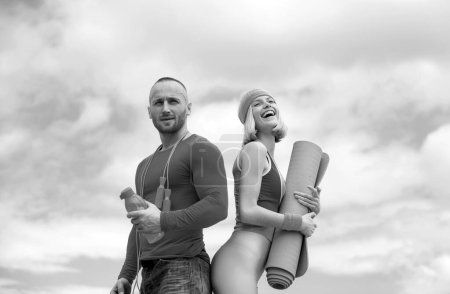 Photo for Sporty funny couple workout with dumbbells. Active happy fun couple exercising outdoors. Sky on the background - Royalty Free Image