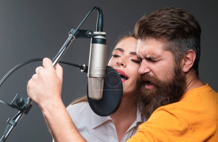 Photo for Karaoke singer couple. Man and woman singing with music microphone - Royalty Free Image