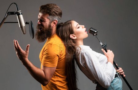 Photo for Couple singing. Singing man and girl in a recording studio. Expressive couple with microphone. Karaoke signer, musical vocalist - Royalty Free Image