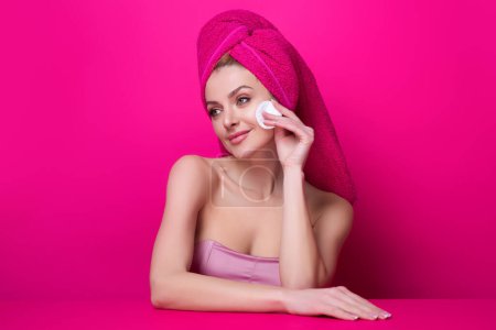 Foto de Woman with cotton pad. Toner for cleaning make up. Clean healthy skin, studio background. Beauty woman holding cotton pad, applying cleansing lotion facial wipe on face, removing makeup - Imagen libre de derechos