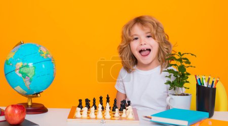 Photo for Excited kid play chess. Funny child. Chess game for kids. Intelligent, smart and clever school boy. Portrait of cute child play chess on studio isolated background - Royalty Free Image