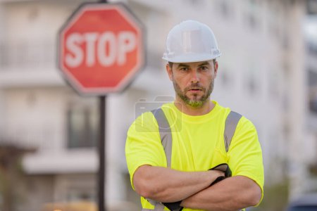 Photo for Worker in uniform gesturing stop. Serious engineer with stop road sign. Builder with stop gesture, no hand, dangerous on building concept. Man in helmet showing stop road sign - Royalty Free Image