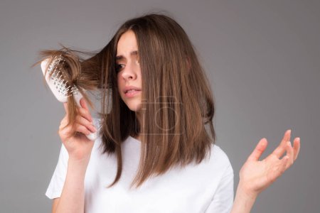 Téléchargez les photos : Femme stressée est très contrariée à cause de la perte de cheveux. Couper les cheveux et lisser les soins capillaires. Problème sérieux de perte de cheveux pour le shampooing de soins de santé - en image libre de droit