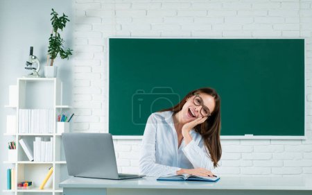 Photo for Portrait of smiling young college student studying with laptop computer in classroom. Online learning at school, distance education - Royalty Free Image