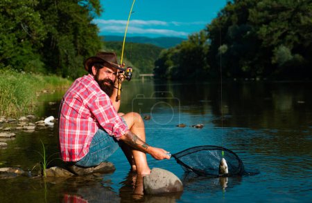 Photo for Fishing hobby and summer weekend. Bearded men fisher with fishing rod and net. Catching trout fish - Royalty Free Image