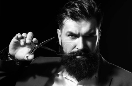 Photo for Closeup bearded man, portrait of man with long beard and moustache. Barber scissors for barber shop. Vintage barbershop, shaving. Brutal serious male with modern hairstyle on black - Royalty Free Image
