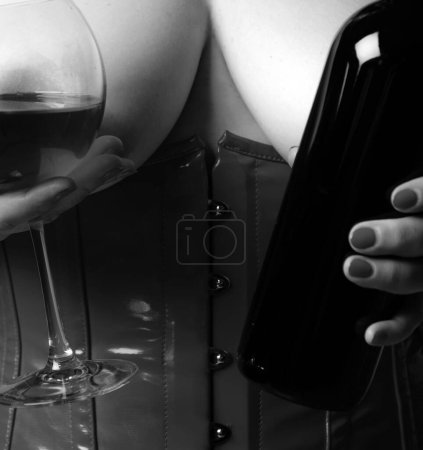 Foto de Wine. Glass red wine. Sensual woman holds in hand vine. Plus size sexy model, women with big naked breasts boobs. Wine festival - Imagen libre de derechos