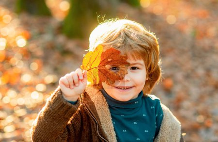 Foto de Otoño niños, precioso niño jugando en el parque de otoño - Imagen libre de derechos