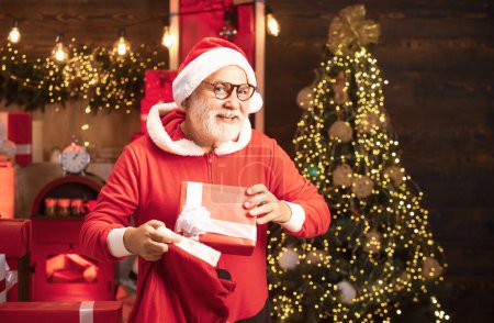 Téléchargez les photos : Carte de voeux de Noël avec le Père Noël. Père Noël avec cadeau de Noël. Portrait d'un Père Noël mature - en image libre de droit