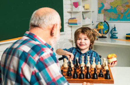 Photo for Family relationship between grandfather and grandson. Grandpa teaching school boy playing chess. Portrait grandpa and grandson playing and learning - Royalty Free Image
