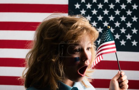 Téléchargez les photos : Kid célébration indépendance jour 4 juillet. Concept des États-Unis d'Amérique. Enfant avec drapeau américain. Jour du Souvenir. Visage drôle d'enfants avec drapeau américain sur la joue. Patriote américain - en image libre de droit