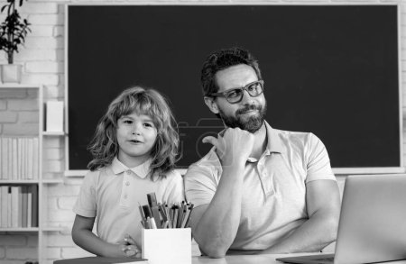 Photo for Father teacher helping a son boy in school lessons. Education and knowledge - Royalty Free Image