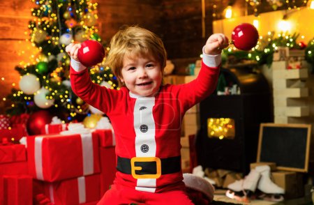 Photo for Check contents of christmas stocking. Joy and happiness. Childhood moments. Kid boy santa hold christmas gift red sock. Christmas stocking concept. Child cheerful face got gift in christmas sock. - Royalty Free Image