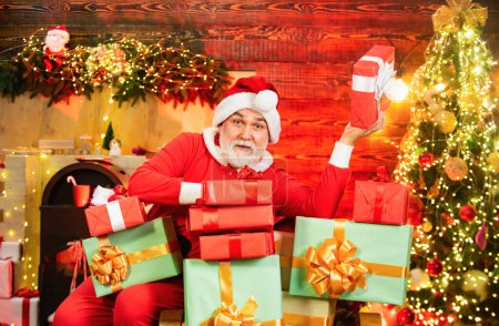 Téléchargez les photos : Homme barbu s'amuser près de l'arbre de Noël à l'intérieur. Nouvel an concept de Noël. Beau homme en robe de Noël - en image libre de droit