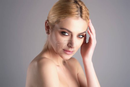 Foto de Youth and skin care concept. Photo of sensual model isolated on studio background. Close up portrait of beautiful woman with soft clean pure skin. Beauty face of young woman with red lipstick on lips - Imagen libre de derechos