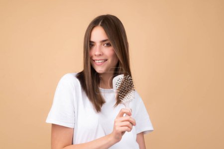Photo for Portrait of charming brunette hair lady combing hair with hairbrush comb, isolated - Royalty Free Image