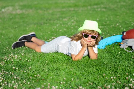 Photo for Kids relaxation. Child laying in grass in the park. Summer holiday activitie. Kid boy are relaxing outdoor. Carefree kid boy having fun on spring day at the park - Royalty Free Image