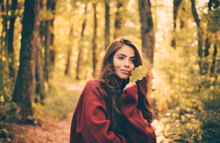 Foto de Modelo romántico de mujer de otoño. Retrato de una hermosa mujer caucásica caminando al aire libre. Mujer de otoño divirtiéndose en el parque y sonriendo - Imagen libre de derechos