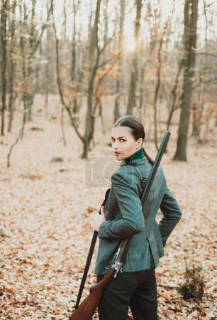 Foto de Mujer cazadora cazando. Caza en el bosque de otoño. Retrato de la bella mujer Hunter. Temporada de caza - Imagen libre de derechos
