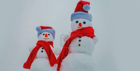 Téléchargez les photos : Des bonhommes de neige drôles. Deux bonhomme de neige sur fond de neige - en image libre de droit