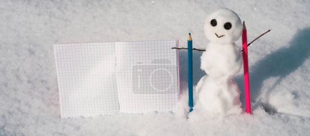 Photo for Snowman writer at work. Planner note book. Snow man with notes. Blog creation concept with snowman, freelance work business and marketing - Royalty Free Image