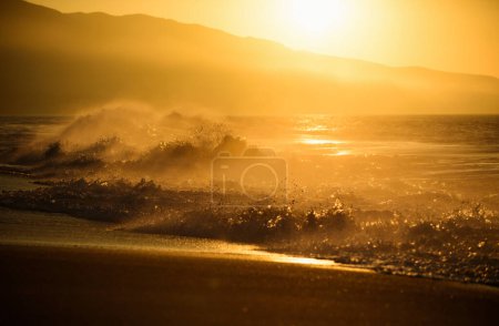 Photo for Gold sky and sea water. Sunrise background. Sunset with large yellow sun under the sea surface. Waves splashes - Royalty Free Image