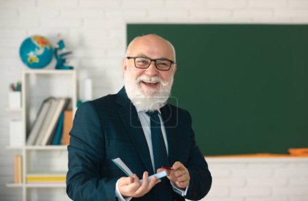Foto de Sonriente feliz madura elegante profesor con gafas. Concepto de educación y conocimiento. Día del maestro - Imagen libre de derechos