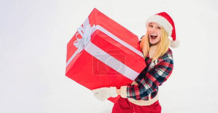 Téléchargez les photos : Portrait de Santa femme avec un énorme cadeau rouge. Femme de Noël tenant un énorme cadeau - en image libre de droit