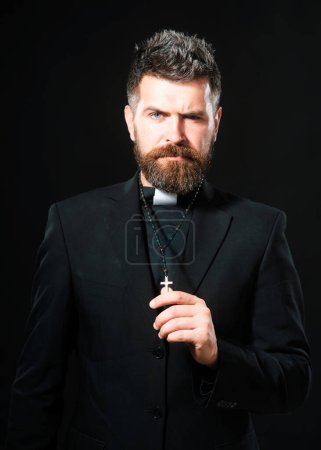 Photo for Religion concept. Handsome hispanic catholic priest man over black isolated background. Pastor or preacher praying, priest portrait of male pastor - Royalty Free Image
