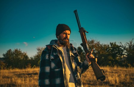 Photo for Hunter with shotgun gun on hunt. Bearded hunter man holding gun and walking in forest - Royalty Free Image