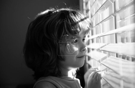 Photo for Qarantine concept. Protect yourself. Stay home in self isolation. COVID-19 Lockdown. Child looking through window. Coronavirus pandemic - Royalty Free Image