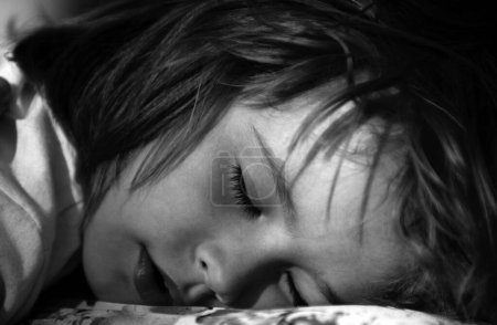 Téléchargez les photos : Closeup face of kid lying in bed and sleeping. Child sleep quietly calmly on bed at home. Adorable cute toddler or baby sweet dreaming in bedroom. Lovely child get deep sleep and get relax - en image libre de droit