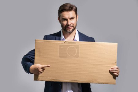 Photo for Man in suit holds sign with copy space. Placard ready for copy space product. Sign to your copy space text. Man showing blank board on studio background, pointing finger. Empty copy space blank board - Royalty Free Image