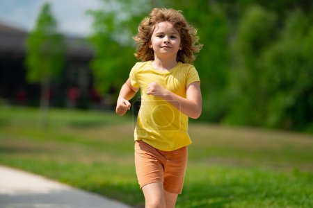 Foto de Lindo chico corriendo por la calle del vecindario americano. Verano, infancia, ocio y concepto de personas. Feliz niño rubio corriendo en el parque de verano al aire libre. Deporte y carrera - Imagen libre de derechos