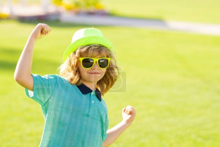 Photo for Excited kids in hat and summer sunglasses. Lifestyle portrait of cute kid outdoors. Summer kids outdoor portrait. Little winner gesture win - Royalty Free Image