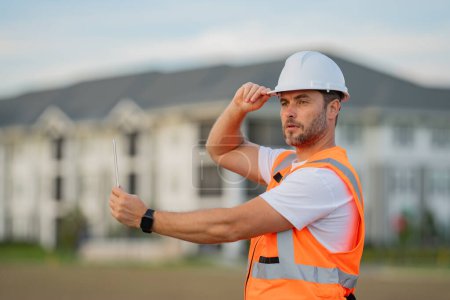 Photo for Portrait of builder man. Construction worker with hardhat helmet on construction site. Construction engineer worker in builder uniform. Worker construction - Royalty Free Image