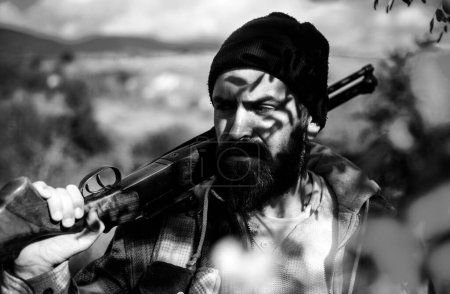 Téléchargez les photos : Un homme tenant un fusil. Chasseur avec fusil de chasse en chasse. Chasse en forêt printanière. Grand match. Repérage - en image libre de droit