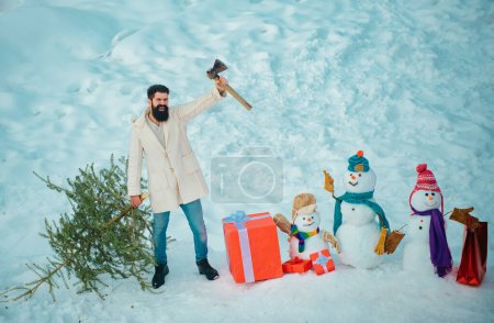 Photo for Man lumberman with Christmas tree in winter park. Winter emotion. Man is going to cut a Christmas tree. Hipster woodsman with Christmas tree - Royalty Free Image